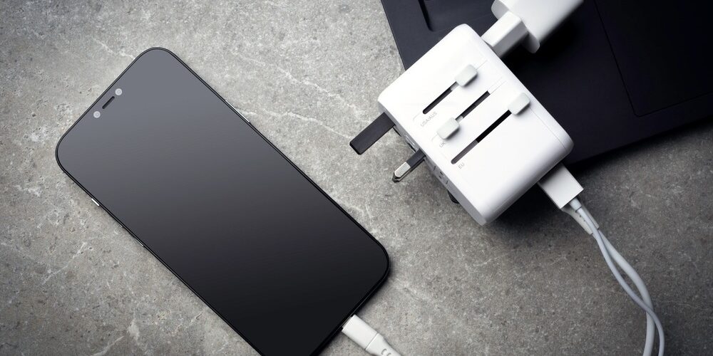 Travel,Adapter,With,Phone,And,Laptop,On,Table. Travel Power